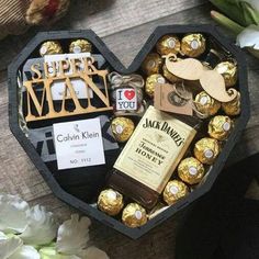 a heart shaped box filled with chocolates and other items on top of a wooden table