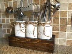 three mason jars with utensils tied in twine on a kitchen counter top