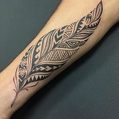 a black and white feather tattoo on the left arm, with an intricate design in the middle