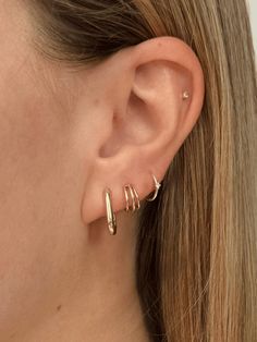 Elevate your earring game with our Triple Hoop Huggie Earrings, crafted from 14k gold. Featuring three sleek hoops seamlessly soldered together, these huggies offer a modern twist on a classic look. Designed to hug your earlobe with a secure butterfly back and post, they’re perfect for adding a touch of bold elegance to any outfit, from everyday wear to special occasions. 1st And 2nd Ear Piercings, 3 Earrings Piercing Ideas, Minimalist Earring Stack, 2 Ear Piercings, Triple Lobe Piercing, Triple Piercing, Second Piercings, Three Ear Piercings, Minimalist Ear Piercings