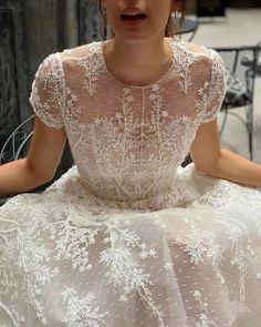 a woman in a white wedding dress sitting down