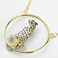 A tawny leopard perches inside a gold hoop Handmade in France Hand painted porcelain Leopard measures 3 inches Gold over brass hoop measures 4 inches 16 inch gold plated chain ABOUT GOLDMAKERS JEWELRY Goldmakers Jewelry creates and curates a comprehensive selection of artfully designed hand-crafted jewelry. We aspire to offer the jewelry enthusiast access to affordable classics as well as fresh innovative designs. ABOUT NACH BIJOUX The Nach Bijoux brand brings a new concept in the market. The or Leopard Necklace, Artfully Designed, Brass Hoops, Round Necklace, Painted Porcelain, Hand Painted Porcelain, Crafted Jewelry, Porcelain Painting, Gold Plated Chains