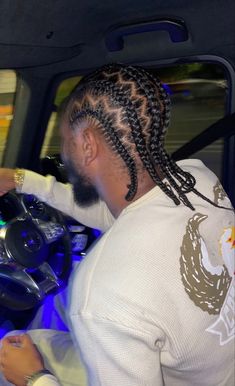 a man with dreadlocks driving a car