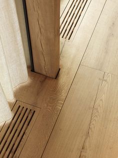 a wooden floor that has been cleaned and is next to a door with a curtain