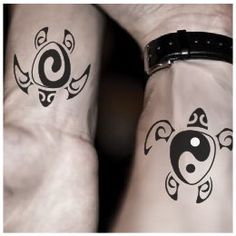 two people with tattoos on their arms and one has a ying - yang symbol in the middle