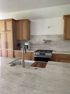 a kitchen with marble counter tops and wooden cabinets