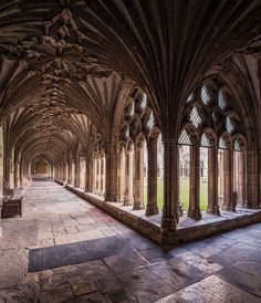 the inside of an old cathedral with stone flooring and arches on both sides,