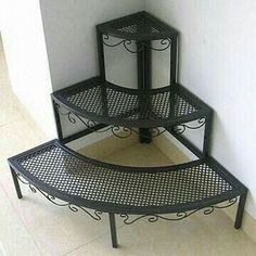 three tiered metal shelf next to a white wall