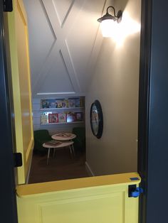 an open door leading to a playroom with a table and chairs in the corner