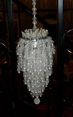 a chandelier hanging from the ceiling in a room with bookshelves behind it