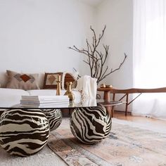 a zebra print ottoman sitting on top of a glass table in front of a couch