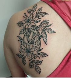 a woman's back with flowers and a turtle tattoo on it