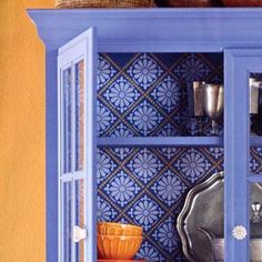 a blue china cabinet filled with dishes and cups