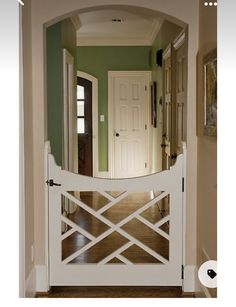 an entryway with a white gate and green walls