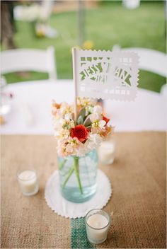 an image of a table setting with flowers in a vase and candles on the table