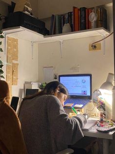 a woman sitting at a desk in front of a computer