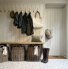 the entryway is clean and organized with baskets, coats, and boot boots hanging on the wall