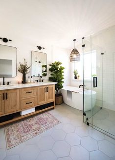 a bathroom with two sinks, a tub and a mirror on the wall next to it