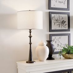 two vases and a lamp are sitting on a mantel in the living room