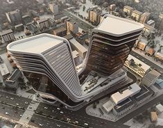 an aerial view of two tall buildings on top of a city street in the snow