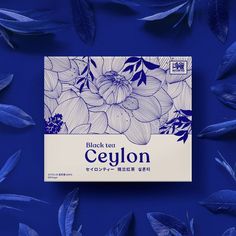 a box of ceylon tea surrounded by leaves on a blue background with the words black tea written in japanese