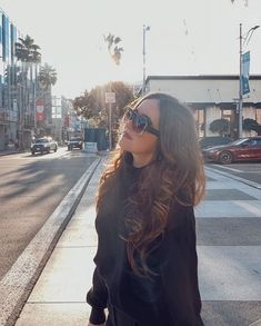 a woman walking down the street with sunglasses on