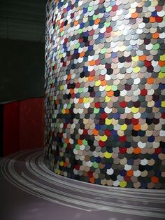 an art installation made out of multiple colored circles on the side of a round building