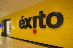 the entrance to an exito store with yellow walls and black letters on it's side