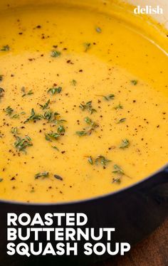 a bowl of roasted butternut squash soup on a wooden table with text overlay reading roasted butternut squash soup