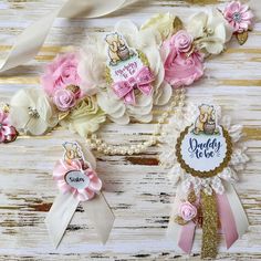 some pink and white flowers are sitting on a table next to each other with ribbons around them