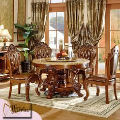 a dining room table and chairs in front of a window with drapes on the windowsill