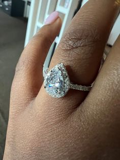 a woman's hand with a diamond ring on top of her finger and an engagement band