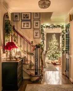 a staircase decorated for christmas with garland and lights on the bannister railings