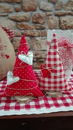 three red and white christmas trees sitting on top of a checkered cloth covered table