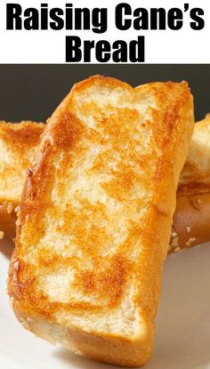 two pieces of toasted bread on a white plate with the words raising cane's bread