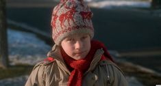 a young boy wearing a red and white knitted hat, scarf and neck tie