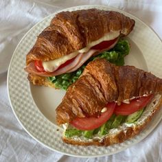 a croissant sandwich with tomatoes and lettuce