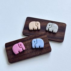 three wooden magnets with elephants on them