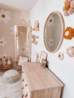 a child's room with flowers on the wall and a wooden desk in front of it