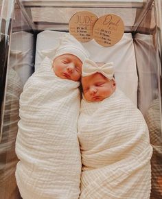 two newborn babies are wrapped in blankets and swaddled with white cloths, sleeping next to each other