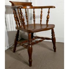 a wooden chair sitting in front of a white wall