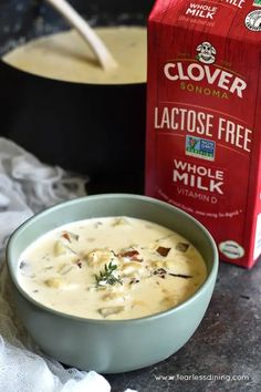 a bowl of soup next to a carton of milk