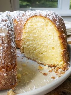 a white plate topped with a cake covered in powdered sugar