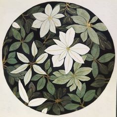 a circular painting with white flowers and green leaves