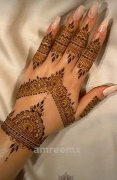 a woman's hand with henna tattoos on it