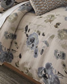 an image of a bed with blue flowers on it's comforter and pillows