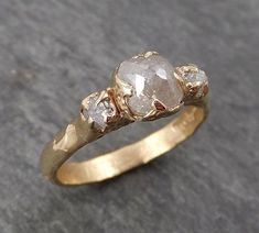 three stone ring sitting on top of a gray surface