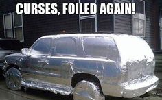 a car wrapped in aluminum foil sitting on the side of a road next to a house