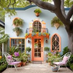 a blue house with potted plants and chairs