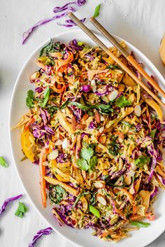 a white plate topped with coleslaw and chopsticks